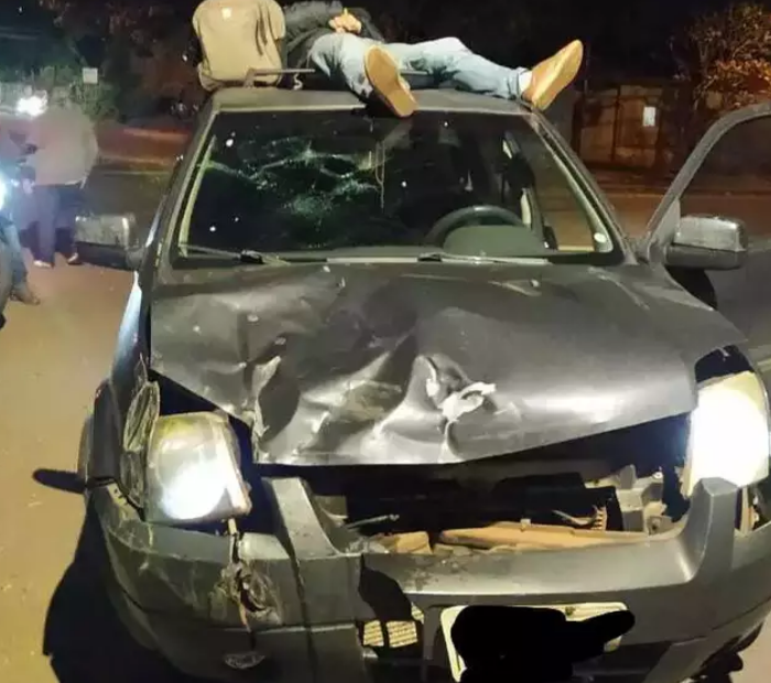 Após colisão, motorista tenta fugir com vítima no teto do carro e acaba preso.